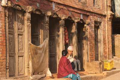 Newari People chatting in front of wooden shop door, in Dhulikhel, Kathmandu Valley, Nepal