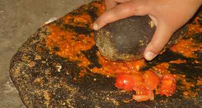 Making Nepali Tomato chutney made on a grinding stone