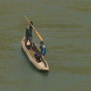Villagers in traditional boat shipping the Karnali river, view from Karnali Highway (Surkhet to Jumla, Western Nepal)