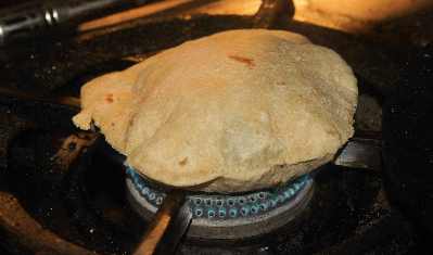 North Indian Food: Indian bread Chapati puffed on a gas flame 